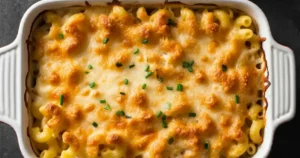 Close-up of Tini's Mac and Cheese, featuring creamy, golden pasta topped with a melted cheese crust, served in a white baking dish